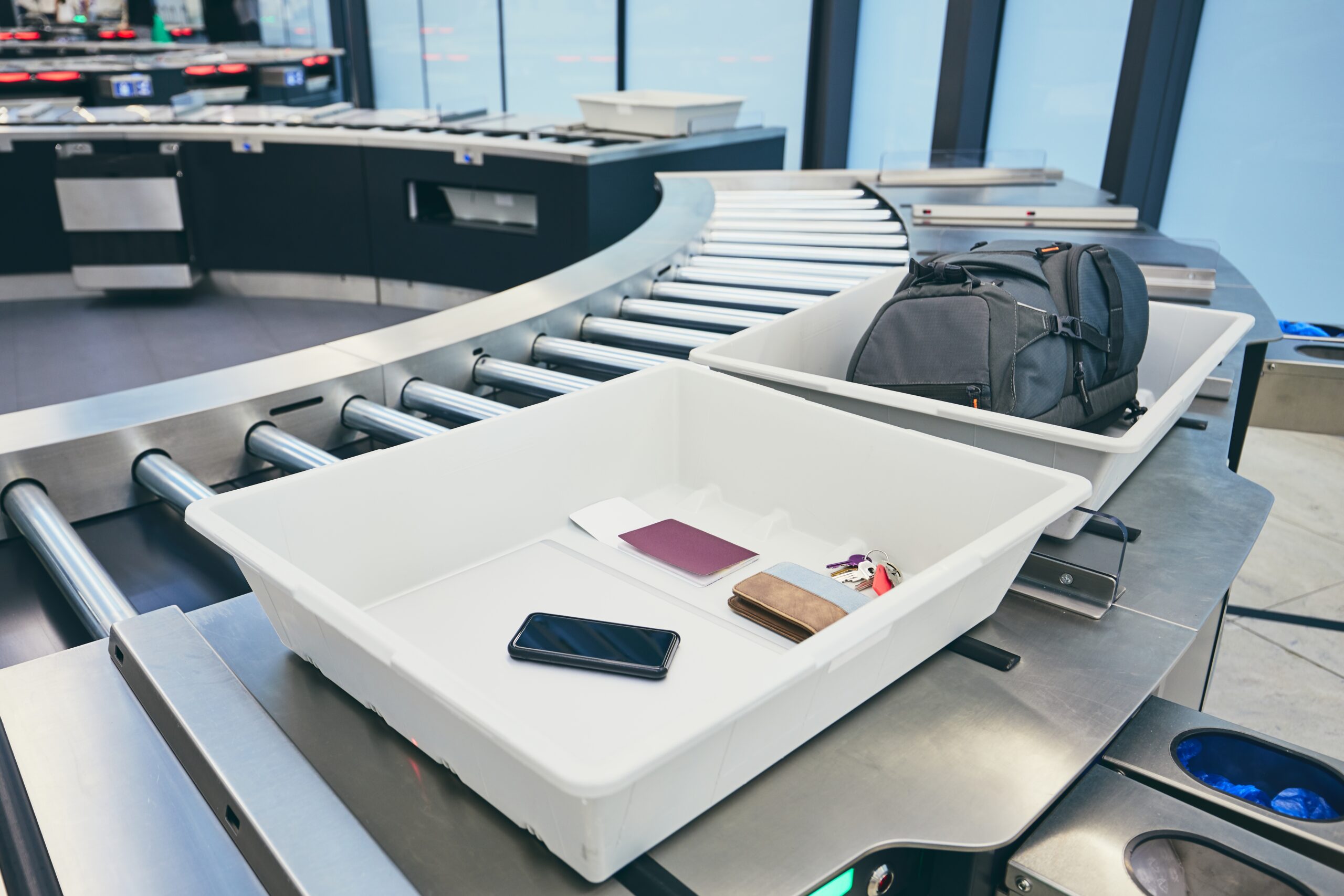 Airport security check. Containers with personal belongings (passport, smart phone, wallet, keys) before x-ray control.